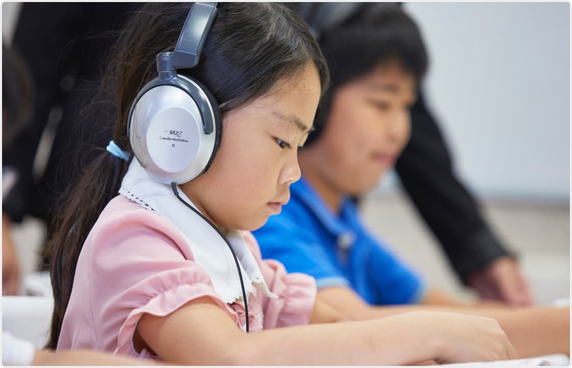 ヘッドホンを使って学ぶ子どもの様子