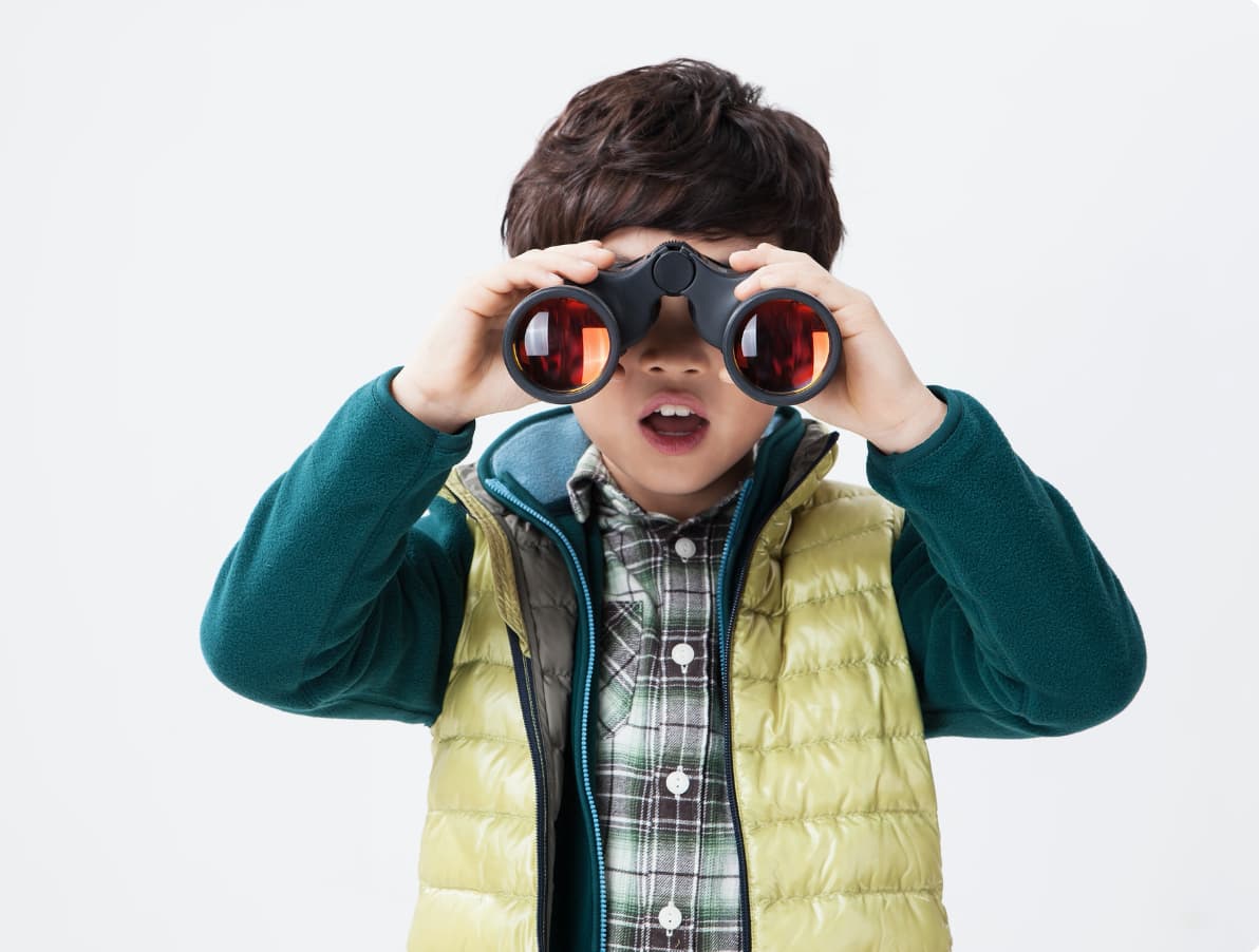 双眼鏡を手に、まだ知らない世界を自分から探している子ども